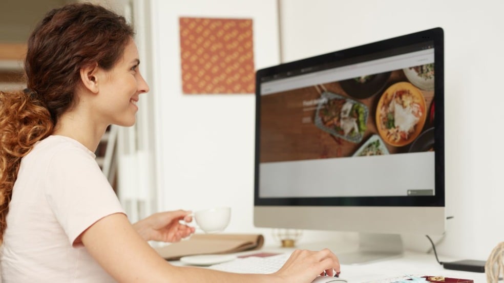 Mulher trabalhando como web designer em casa, usando computador e tomando café. Mulher trabalhando como web designer em casa, usando computador e tomando café.