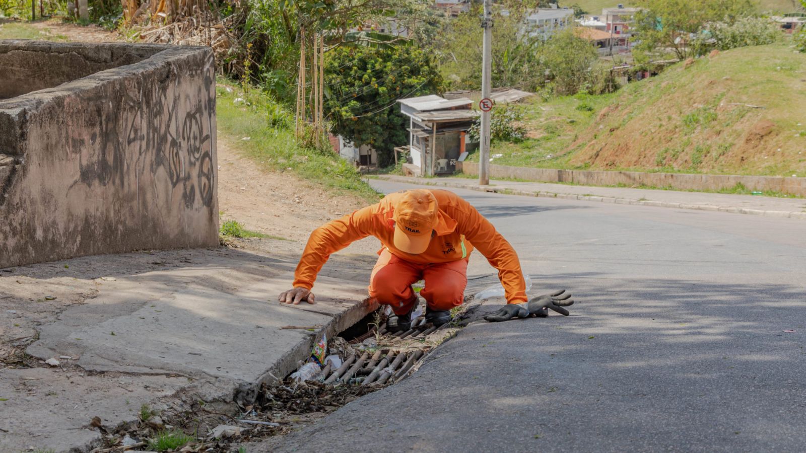 Trabalhador realiza limpeza de boca de lobo em Jundiaí para prevenir alagamentos.