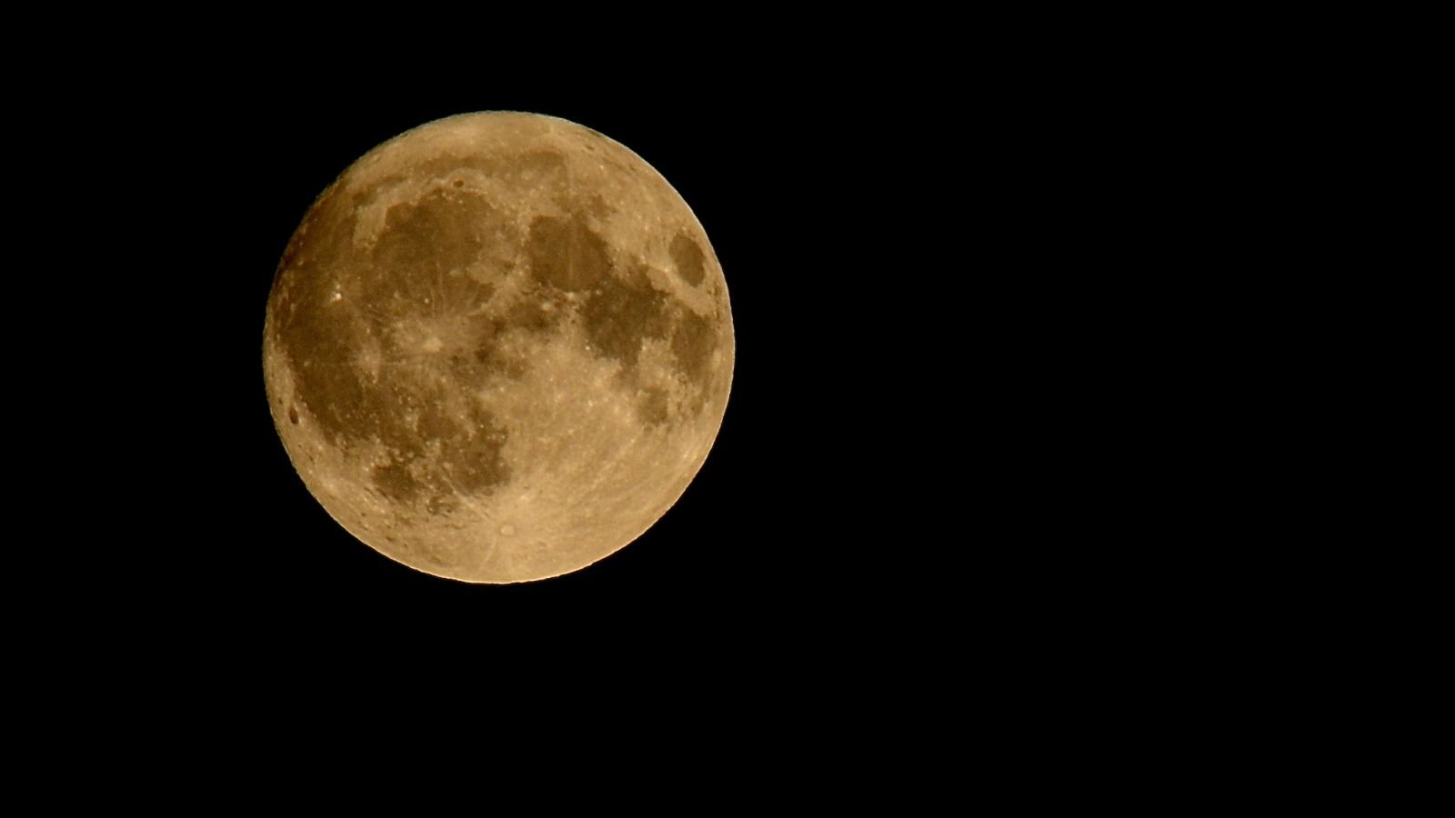 Lua Cheia amarelada no céu noturno representando a Lua do Caçador e a superlua de outubro de 2025.