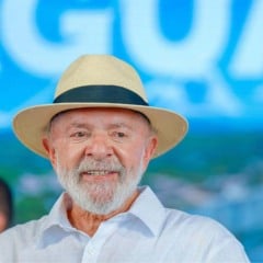 Presidente Lula sorrindo de chapéu de palha durante evento público em 2025.