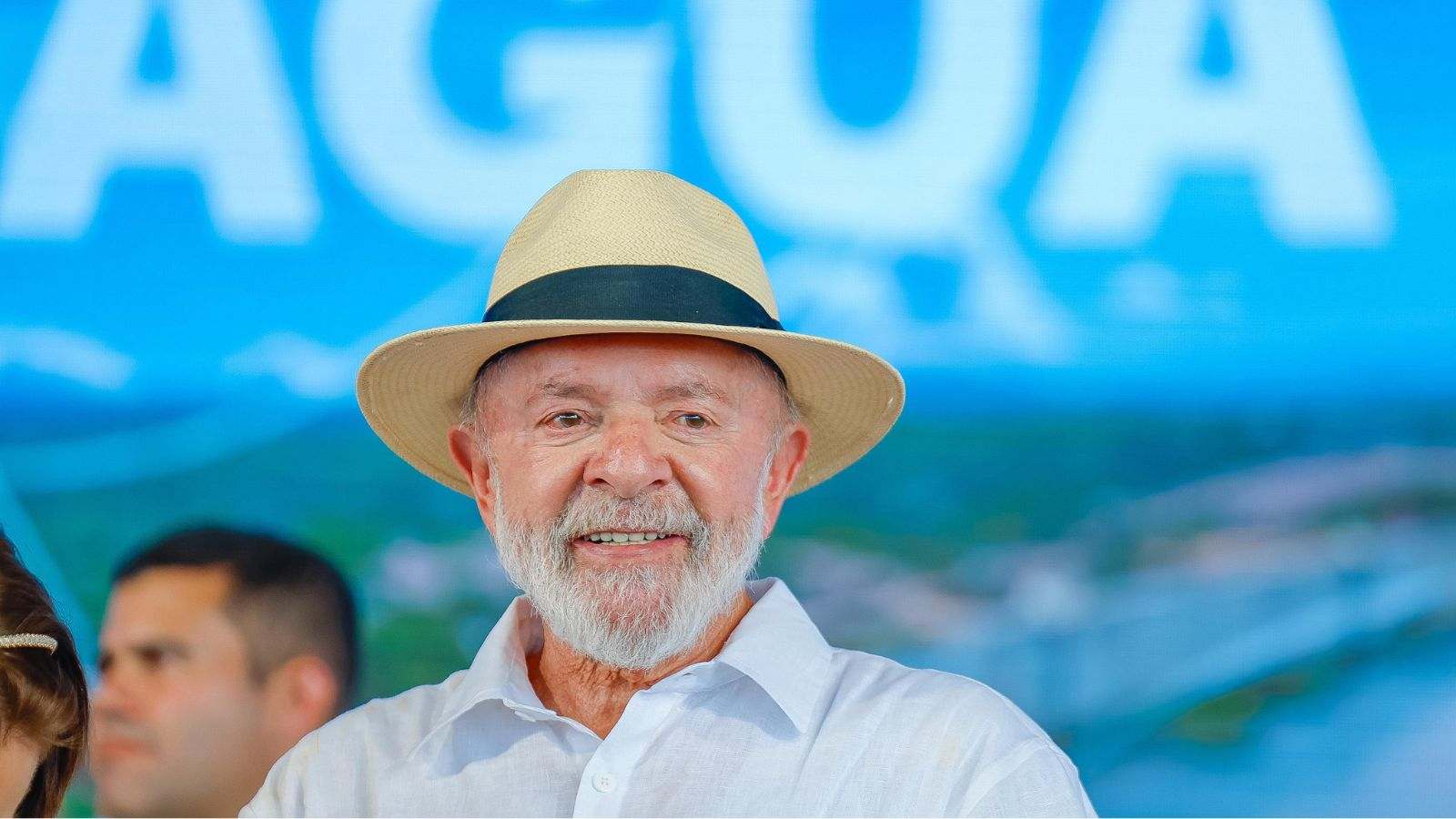 Presidente Lula sorrindo de chapéu de palha durante evento público em 2025.