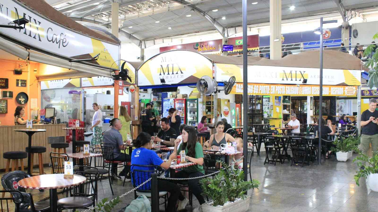 Clientes aproveitam o ambiente do Maxi Mix Armazém no Mercadão da Ferroviários, em Jundiaí, com mesas ocupadas e atendimento movimentado.