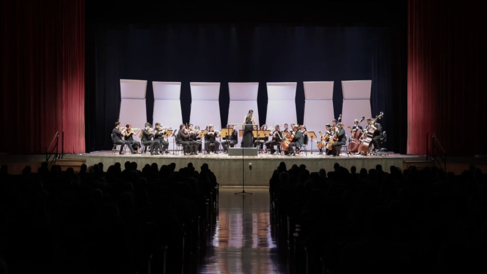 Orquestra Municipal de Jundiaí se apresenta no palco do Teatro Polytheama com regência da maestrina e músicos de cordas diante do público. Orquestra Municipal de Jundiaí se apresenta no palco do Teatro Polytheama com regência da maestrina e músicos de cordas diante do público.