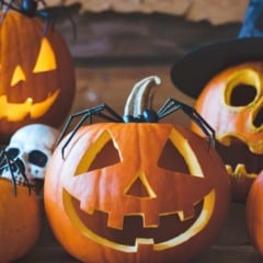 Abóboras iluminadas com rostos esculpidos e decoração de Halloween com caveira e chapéu de bruxa. Abóboras iluminadas com rostos esculpidos e decoração de Halloween com caveira e chapéu de bruxa.