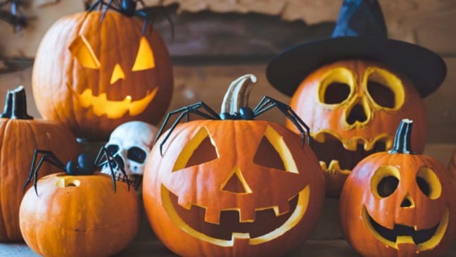 Abóboras iluminadas com rostos esculpidos e decoração de Halloween com caveira e chapéu de bruxa. Abóboras iluminadas com rostos esculpidos e decoração de Halloween com caveira e chapéu de bruxa.