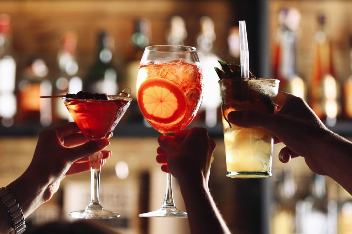 Pessoas brindando com bebidas em bar