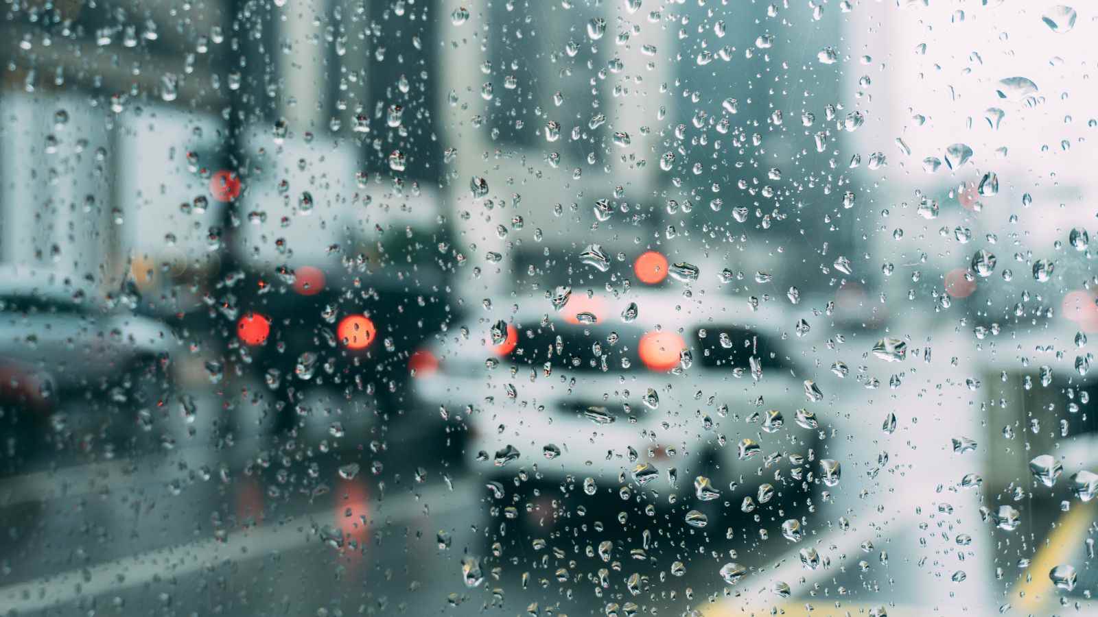 Dia chuvoso em Jundiaí visto através de um para-brisa com gotas d’água, ilustrando a previsão do tempo desta terça-feira.