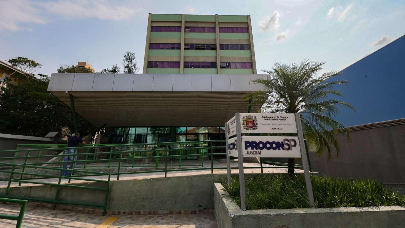 Fachada do Procon Jundiaí, com rampa de acesso e placa de identificação em frente ao prédio anexo da Câmara Municipal.