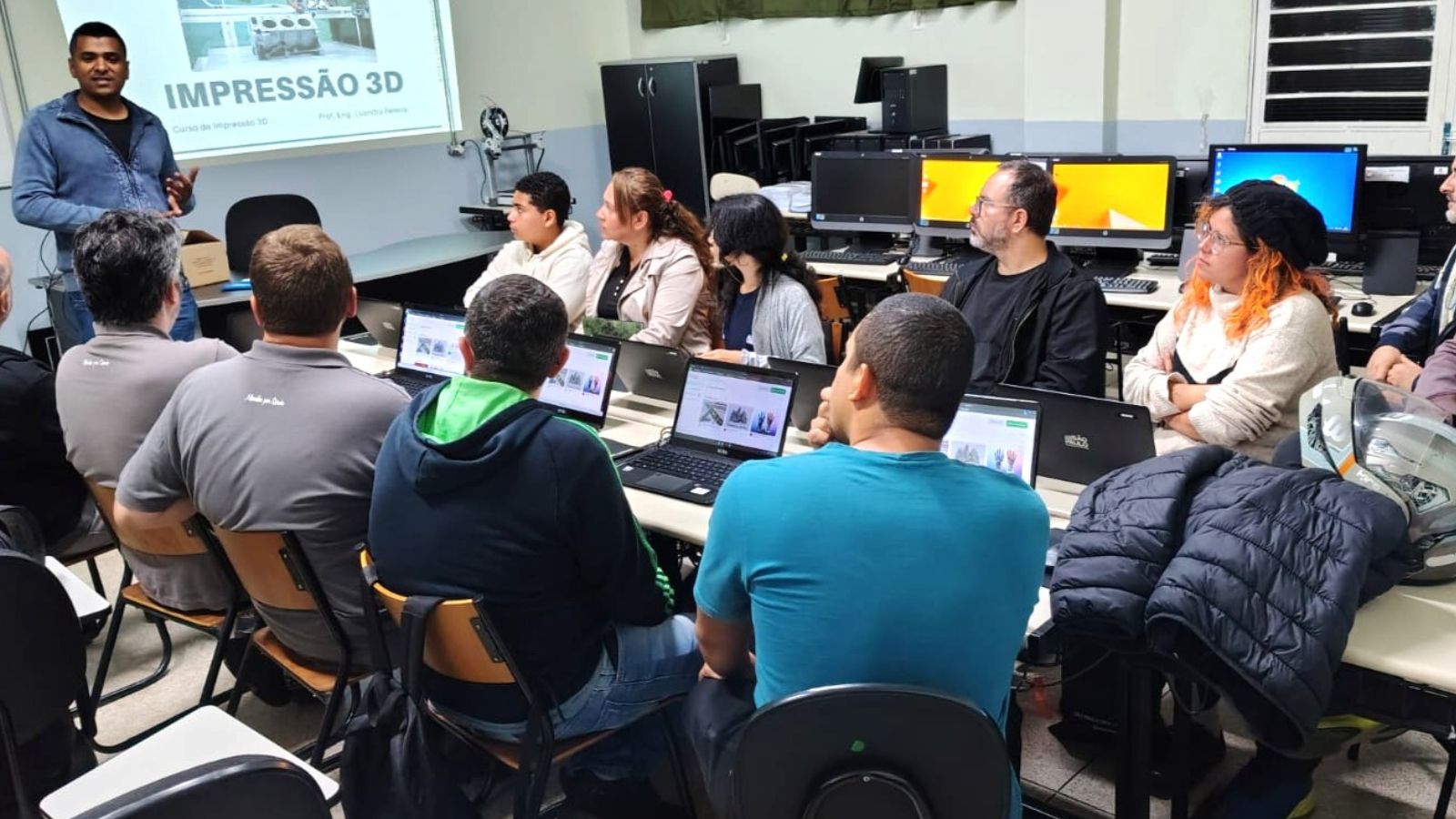 Alunos assistem a aula de Impressão 3D do Programa FormAção em Itatiba, com notebooks e instrutor explicando o conteúdo.