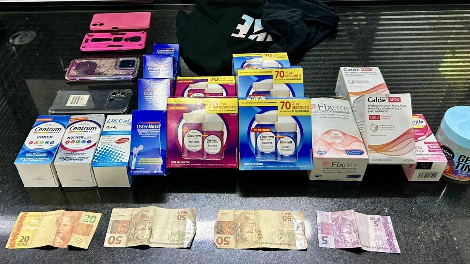 Produtos furtados de farmácias e apreendidos pela Guarda Municipal de Itatiba, incluindo suplementos vitamínicos, celulares e dinheiro.