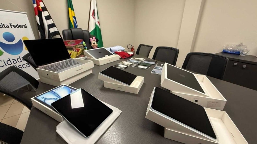 Doação da Receita Federal à Prefeitura de Várzea Paulista com iPhones, iPads e MacBooks expostos sobre mesa no gabinete municipal. Doação da Receita Federal à Prefeitura de Várzea Paulista com iPhones, iPads e MacBooks expostos sobre mesa no gabinete municipal.