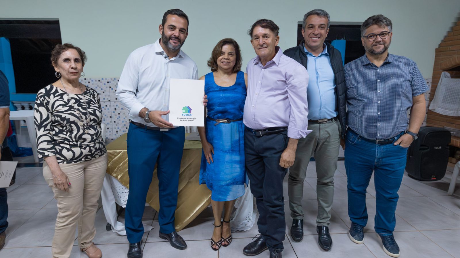 Prefeito de Jundiaí entrega matrícula de regularização fundiária a moradora do Recanto da Toca ao lado de representantes da Prefeitura e da comunidade.