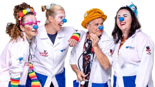 Integrantes do projeto Rumo ao Riso caracterizados como palhaços da saúde, sorrindo e transmitindo alegria durante ação de risoterapia.
