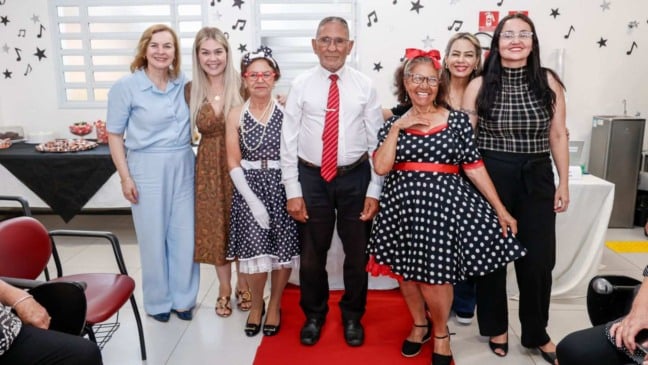 Grupo de idosos e organizadoras posam sorridentes após desfile temático dos anos 60 no CRAS Sul, em Jundiaí, durante a Semana do Idoso.