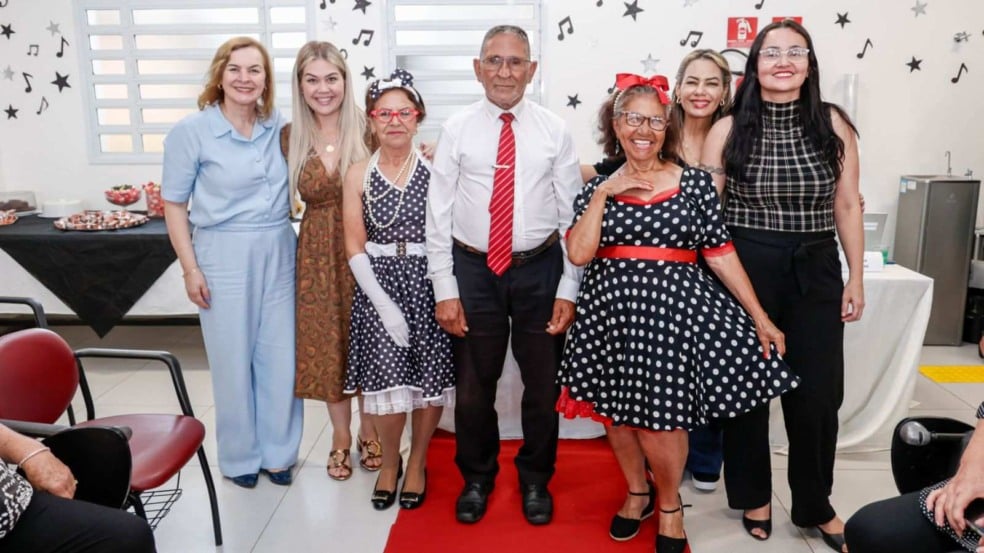Grupo de idosos e organizadoras posam sorridentes após desfile temático dos anos 60 no CRAS Sul, em Jundiaí, durante a Semana do Idoso.