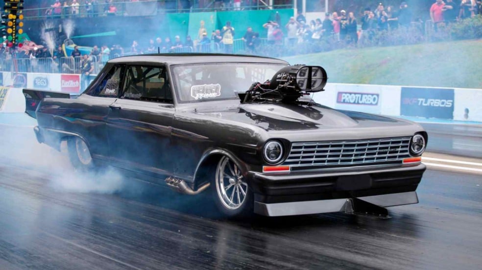 Carro de arrancada preto em ação na SPID, com fumaça dos pneus e público ao fundo na SpidCup 2025. Carro de arrancada preto em ação na SPID, com fumaça dos pneus e público ao fundo na SpidCup 2025.