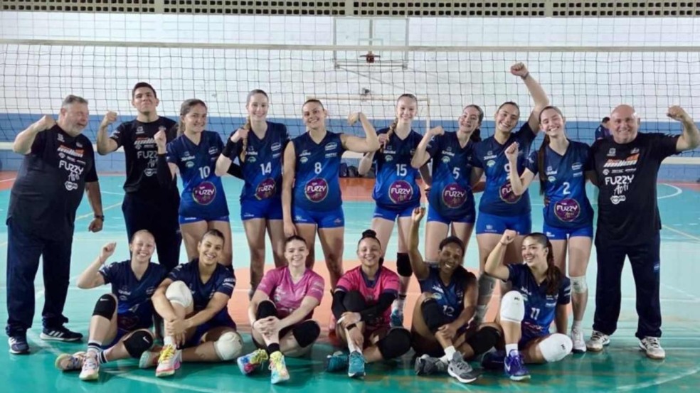 Time Jundiaí Sub-19 de vôlei feminino posa em quadra após vitória por 3 a 0 sobre Praia Grande no Campeonato Estadual, com jogadoras e comissão técnica comemorando. Time Jundiaí Sub-19 de vôlei feminino posa em quadra após vitória por 3 a 0 sobre Praia Grande no Campeonato Estadual, com jogadoras e comissão técnica comemorando.