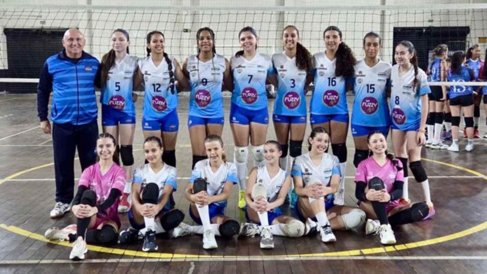 Time Jundiaí Sub-14 de voleibol feminino posa com o técnico em quadra após vitória sobre Mauá no Campeonato Estadual.