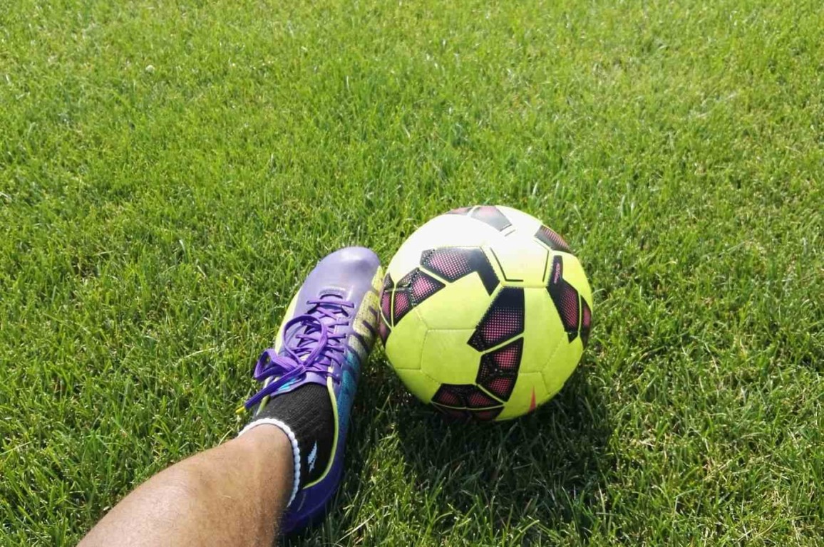 Jogador do Vila Nova com chuteira roxa e bola amarela no gramado verde, destacando o espírito esportivo do futebol. Jogador do Vila Nova com chuteira roxa e bola amarela no gramado verde, destacando o espírito esportivo do futebol.