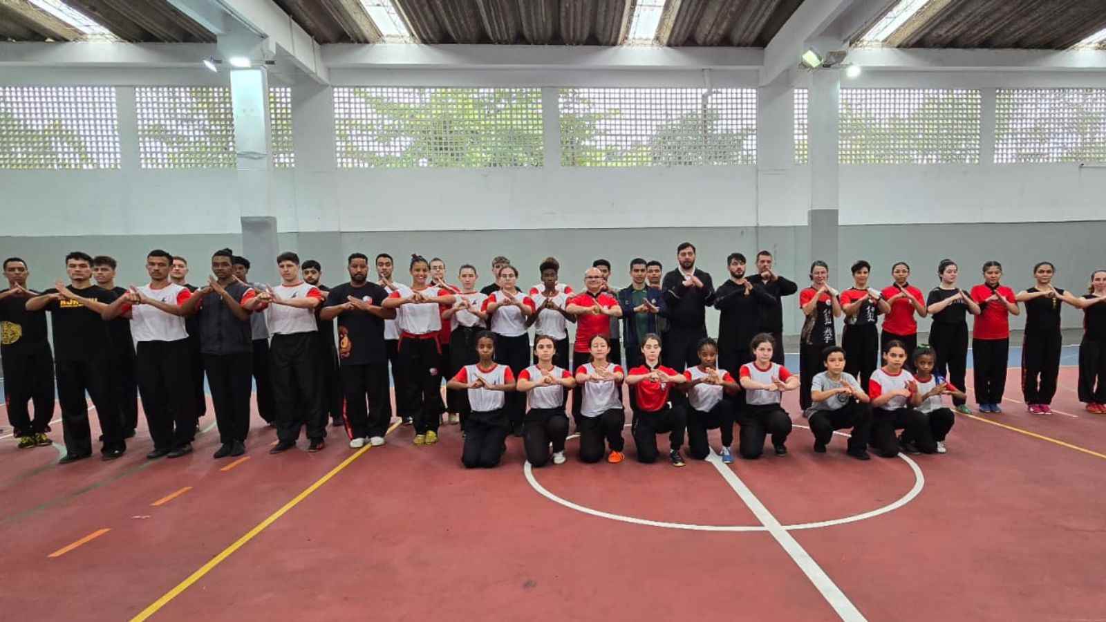Grupo de atletas de Kung Fu Wushu faz o cumprimento marcial durante treino especial na Escola Ana Paes em Jundiaí.