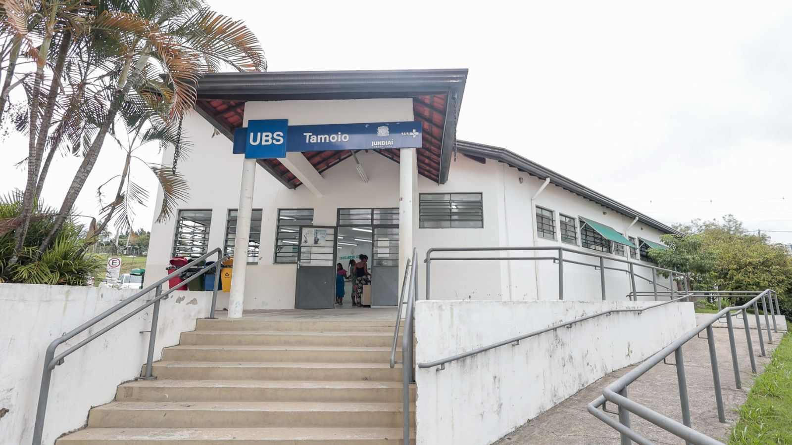 Fachada da Unidade Básica de Saúde (UBS) Tamoio, em Jundiaí, com escadaria e rampa de acesso na entrada.