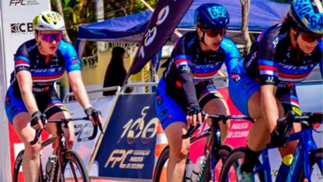 Ciclistas de Jundiaí em ação durante a 26ª Volta Ciclística Internacional do Grande ABCD, no circuito de chegada em Diadema, com uniformes azuis e pretos.