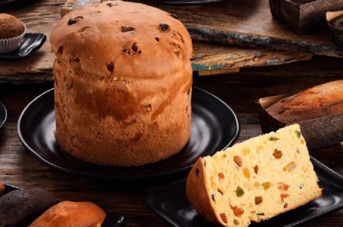 Panetone artesanal Romanato com frutas cristalizadas em destaque sobre prato preto. Panetone artesanal Romanato com frutas cristalizadas em destaque sobre prato preto.