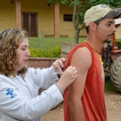 Profissional de saúde aplica vacina contra a febre amarela em morador de área rural durante campanha casa a casa em Jundiaí.