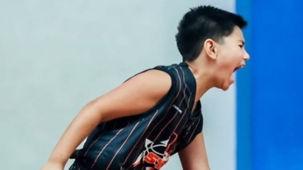 Terceira imagem: Jogador de basquete da RM Stars observa atentamente o adversário enquanto se posiciona na defesa, durante uma partida em quadra coberta.