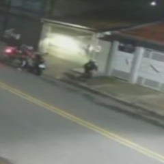 Cena capturada por câmera de segurança mostra dois homens em uma moto assaltando uma motociclista na Avenida Pacaembu, em Várzea Paulista.