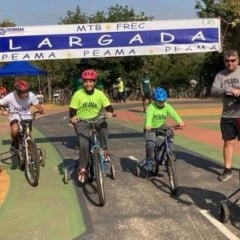 Crianças com bicicletas adaptadas largam em prova do Festival Regional de Ciclismo do PEAMA no Parque da Cidade, em Jundiaí, sob a faixa de “Largada”.
