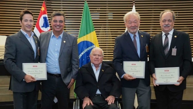 Cinco dirigentes do CIESP posam para foto de posse em São Paulo; quatro em pé com certificados e um sentado ao centro, diante das bandeiras do Brasil e de São Paulo.