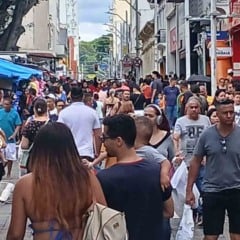 Calçadão do Centro de Jundiaí cheio de pessoas fazendo compras em dia de comércio aberto, com lojas e barracas ao fundo.