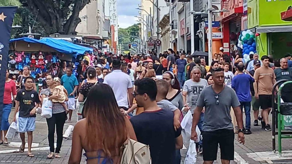 Calçadão do Centro de Jundiaí cheio de pessoas fazendo compras em dia de comércio aberto, com lojas e barracas ao fundo.