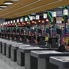 Interior do Covabra Supermercados com dezenas de caixas alinhados, iluminação moderna e prateleiras ao fundo.