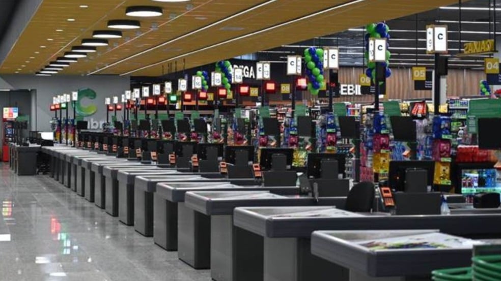 Interior do Covabra Supermercados com dezenas de caixas alinhados, iluminação moderna e prateleiras ao fundo.