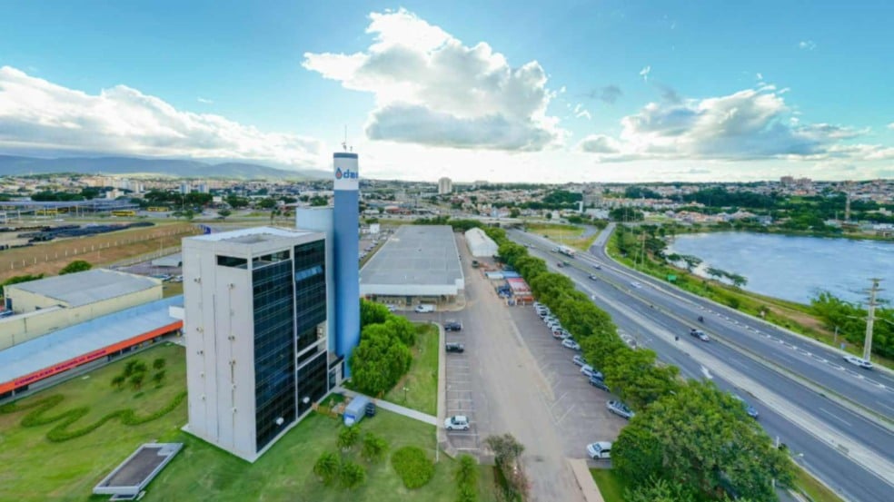 Imagem aérea da sede da DAE Jundiaí, mostrando o prédio administrativo, a torre azul, a Rodovia Anhanguera e o Parque da Cidade ao fundo.