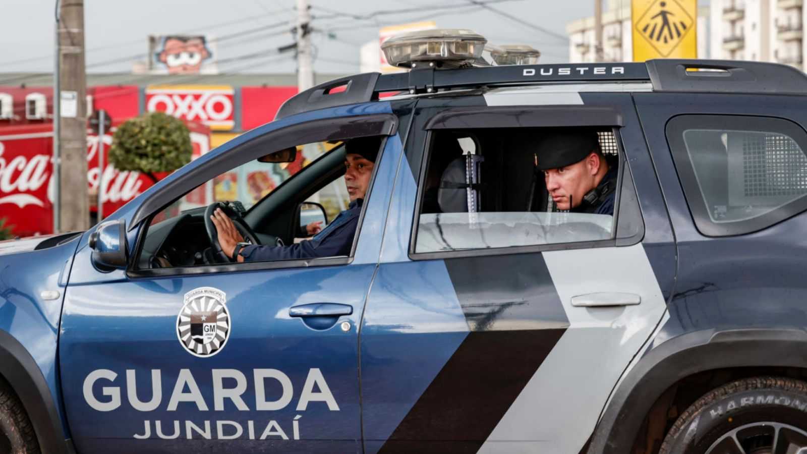 Agentes da Guarda Municipal de Jundiaí em patrulhamento dentro de viatura oficial nas ruas da cidade.