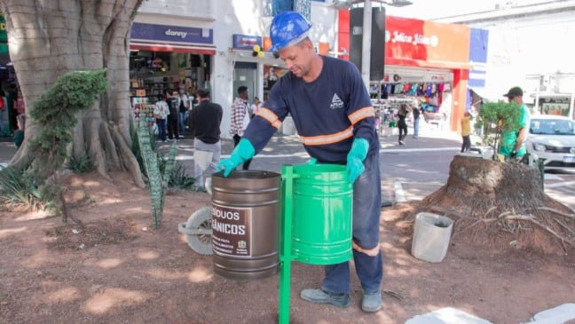 Funcionário da Prefeitura de Jundiaí instalando novas lixeiras de resíduos orgânicos e recicláveis no Centro da cidade.