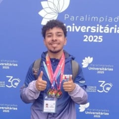 João Vitor Campos Leal posa sorridente com três medalhas no peito durante as Paralimpíadas Universitárias 2025 em São Paulo.