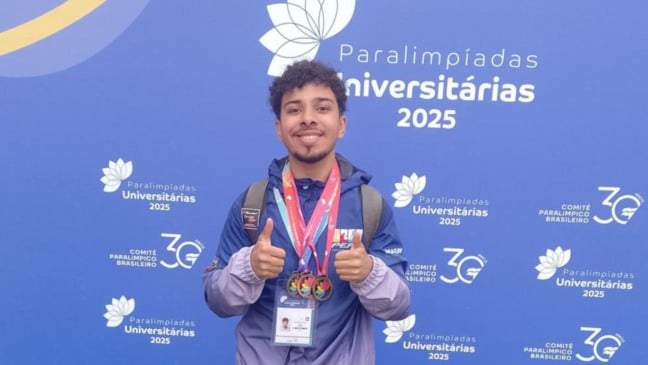 João Vitor Campos Leal posa sorridente com três medalhas no peito durante as Paralimpíadas Universitárias 2025 em São Paulo.