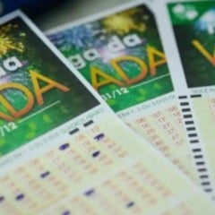 Volantes da Mega da Virada com fundo verde e fogos de artifício, mostrando números preenchidos para o sorteio de 31 de dezembro.