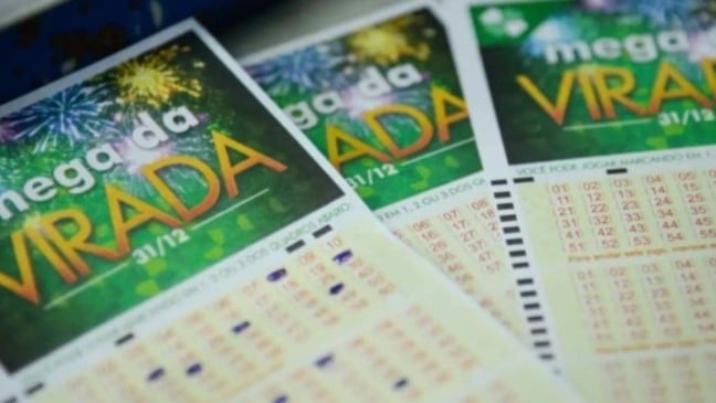 Volantes da Mega da Virada com fundo verde e fogos de artifício, mostrando números preenchidos para o sorteio de 31 de dezembro.