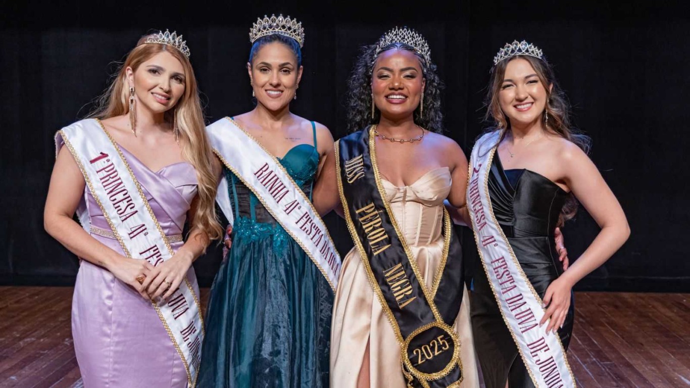 Miss Pérola Negra 2025 posa sorrindo ao lado da Rainha e das Princesas da Corte da Uva 2026, todas usando coroas e faixas oficiais. Miss Pérola Negra 2025 posa sorrindo ao lado da Rainha e das Princesas da Corte da Uva 2026, todas usando coroas e faixas oficiais.