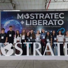 Estudantes do Colégio Degraus segurando a bandeira da escola após participação premiada na Mostratec 2025.