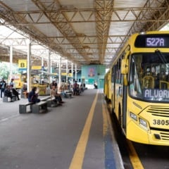 Ônibus amarelo da linha 527A no Terminal Central de Jundiaí, com passageiros aguardando nas plataformas sob cobertura metálica.