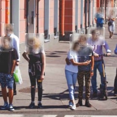 Grupo de pedestres em uma rua movimentada com seus rostos desfocados e marcadores digitais simulando reconhecimento facial, incluindo pessoas caminhando e duas usando patinetes elétricos.