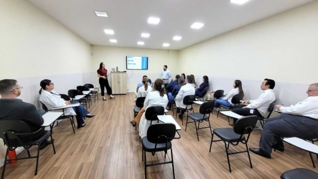 Profissionais do Hospital São Vicente assistem à apresentação do Projeto Boas Práticas – HCor em sala de treinamento, conduzida por Camila Toth e Jean Chini.