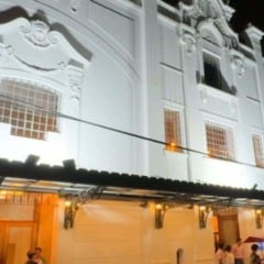 Fachada iluminada do Teatro Polytheama à noite, em Jundiaí, com pessoas reunidas na entrada principal sob a marquise.