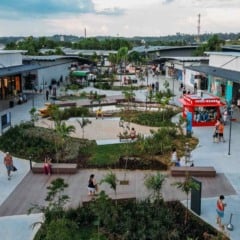 Vista aérea do Outlet Premium São Paulo em Itupeva com visitantes caminhando entre lojas e área ajardinada.